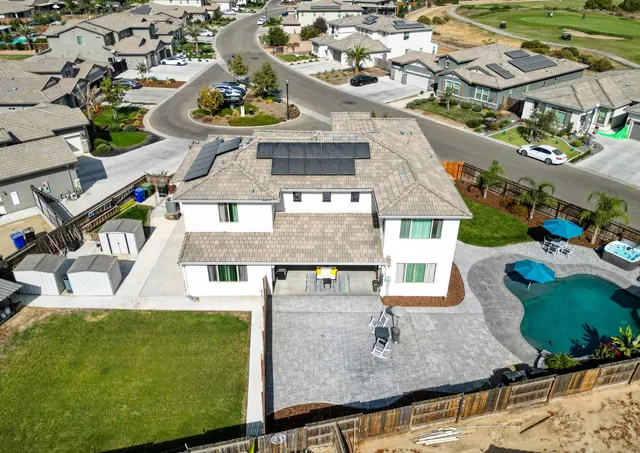 an aerial view of residential houses with outdoor space and parking