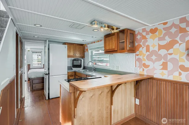a utility room with stainless steel appliances kitchen island granite countertop a sink and cabinets