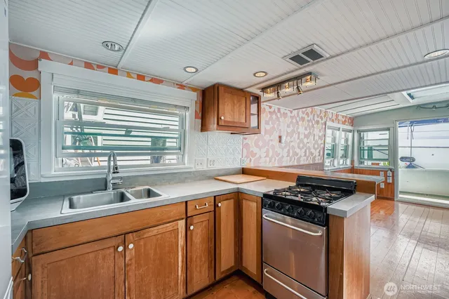 a kitchen with stainless steel appliances granite countertop a sink stove and cabinets