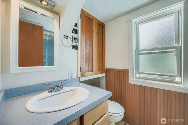 a bathroom with a toilet a sink and mirror