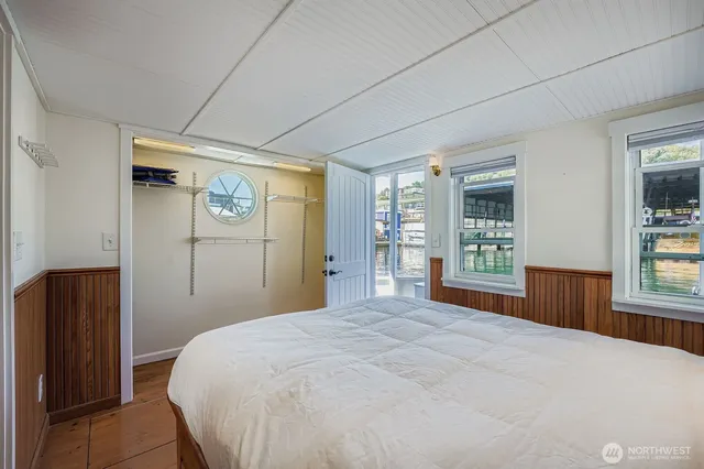 a bedroom with a large bed and wooden floor
