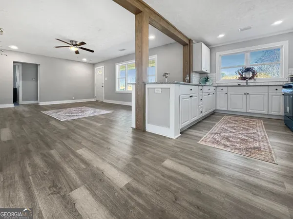 a view of a kitchen with kitchen island a sink stainless steel appliances and cabinets