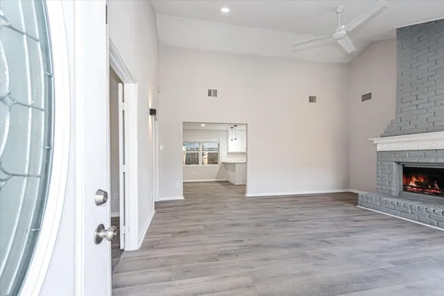 a view of a hallway with wooden floor and a fireplace