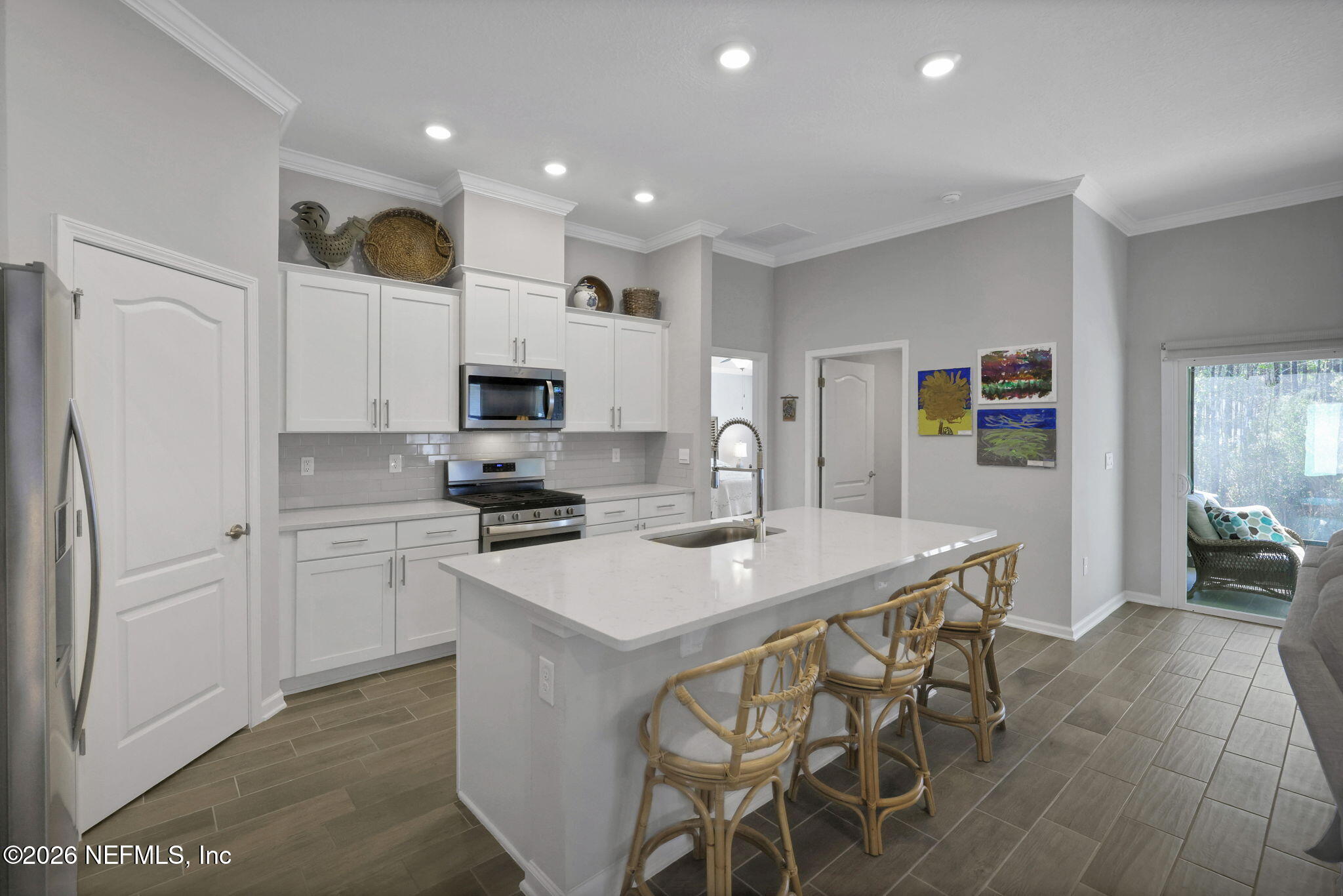 84 Cardinal Branch Lane St. Augustine, FL 32095 - Photo 12 of 45 a kitchen with stainless steel appliances a stove a sink a refrigerator white cabinets and wooden floor