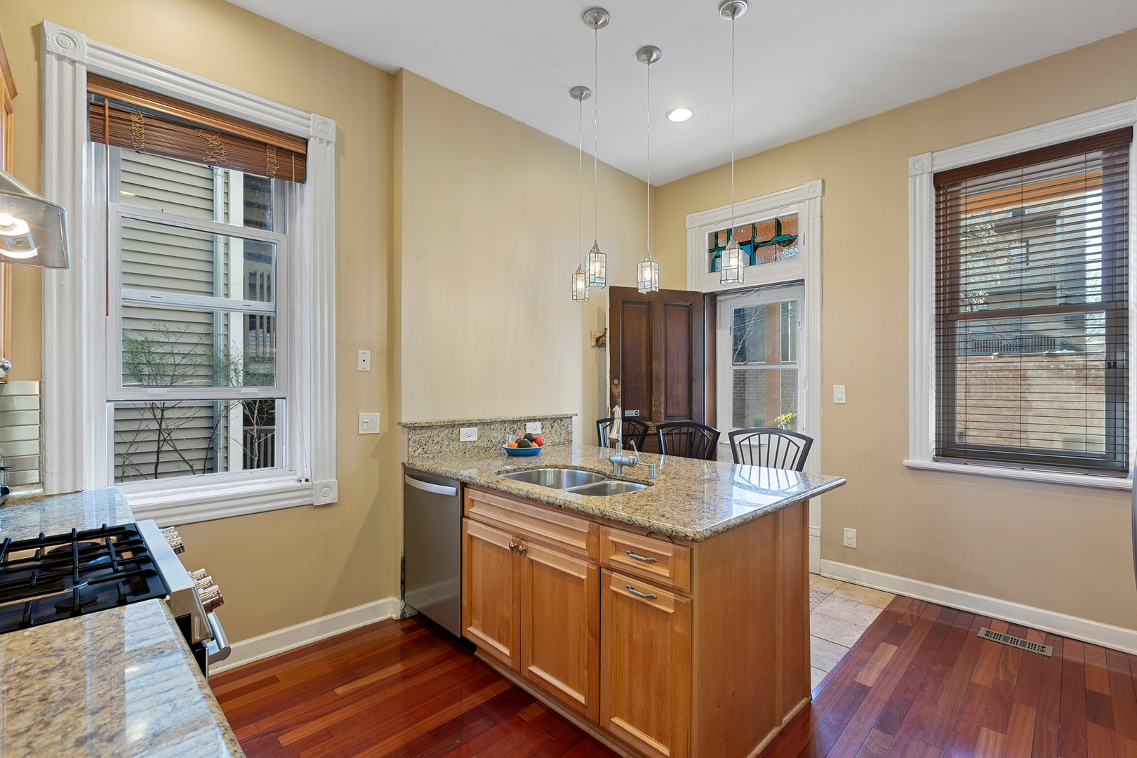929 West Fletcher Street Chicago, IL 60657 - Photo 14 of 53 a kitchen with kitchen island granite countertop a sink stove and wooden floor