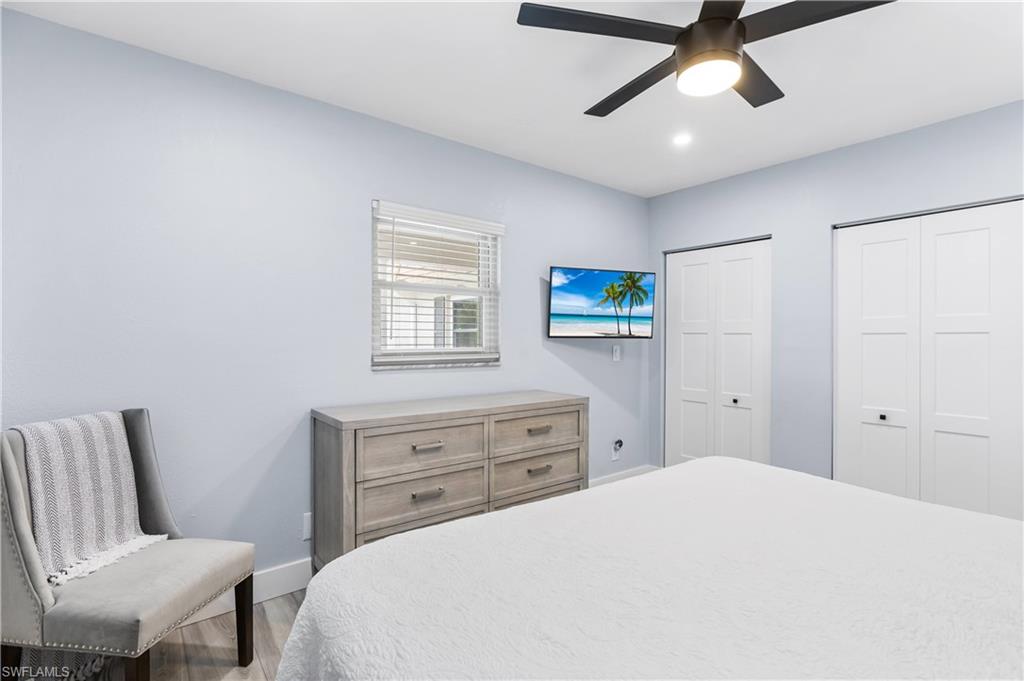940 3rd Street South, Unit 204 Naples, FL 34102 - Photo 11 of 25 a bedroom with a bed and a chandelier