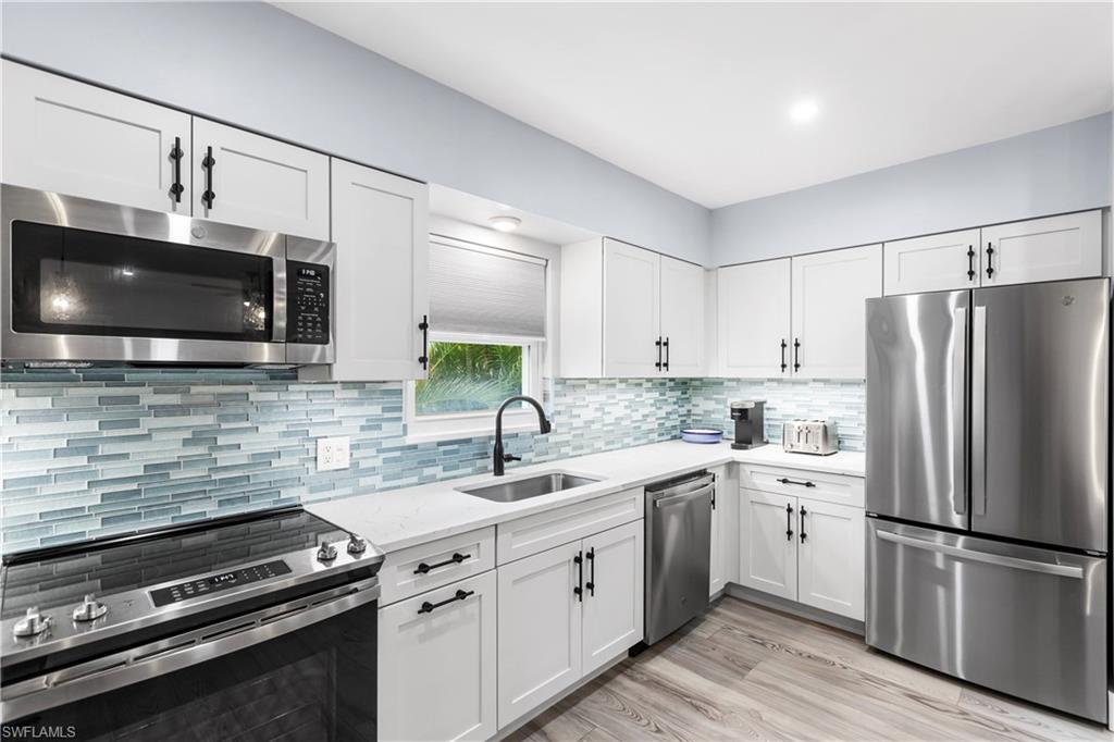 940 3rd Street South, Unit 204 Naples, FL 34102 - Photo 4 of 25 a kitchen with a sink appliances and cabinets