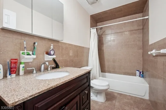 a bathroom with a granite countertop sink a toilet and bathtub