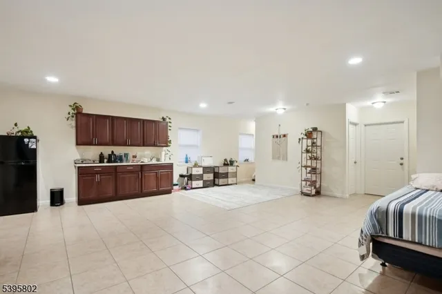 a large bedroom with a bed and a view of kitchen