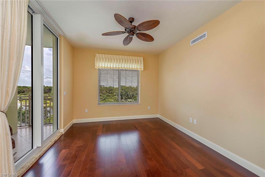 13675 Vanderbilt Drive, Unit 510 Naples, FL 34110 - Photo 11 of 25 wooden floor in an empty room with a window