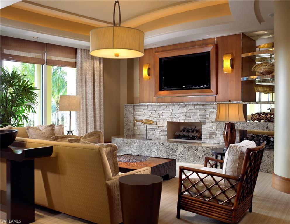 13675 Vanderbilt Drive, Unit 510 Naples, FL 34110 - Photo 15 of 25 a living room with fireplace furniture and a flat screen tv