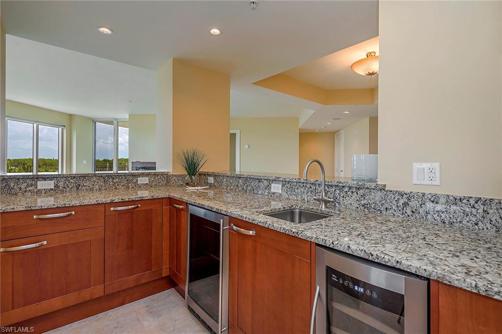 13675 Vanderbilt Drive, Unit 510 Naples, FL 34110 - Photo 7 of 25 a bathroom with a granite countertop sink and a mirror