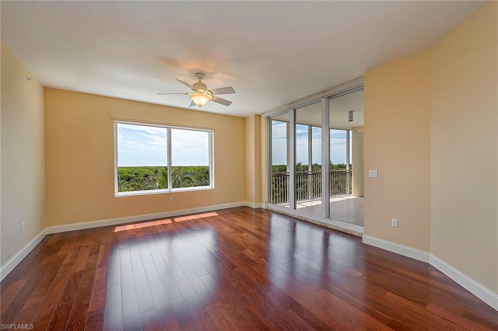13675 Vanderbilt Drive, Unit 510 Naples, FL 34110 - Photo 8 of 25 a view of an empty room with wooden floor and a window