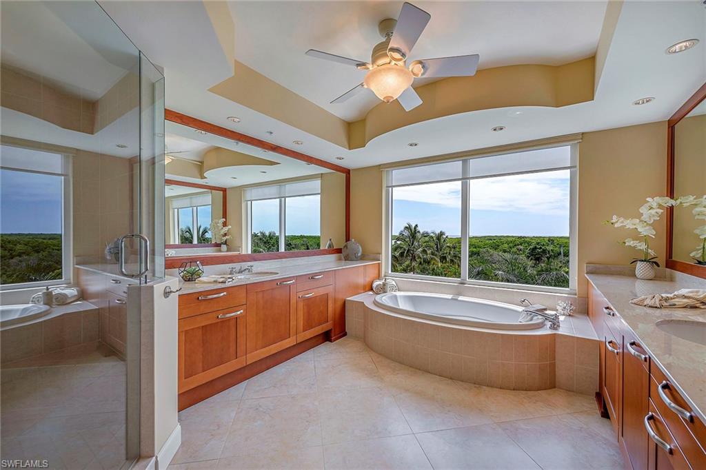 13675 Vanderbilt Drive, Unit 510 Naples, FL 34110 - Photo 9 of 25 a bathroom with a large tub a sink and large window