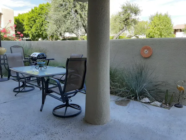 a view of a chairs and table in the backyard