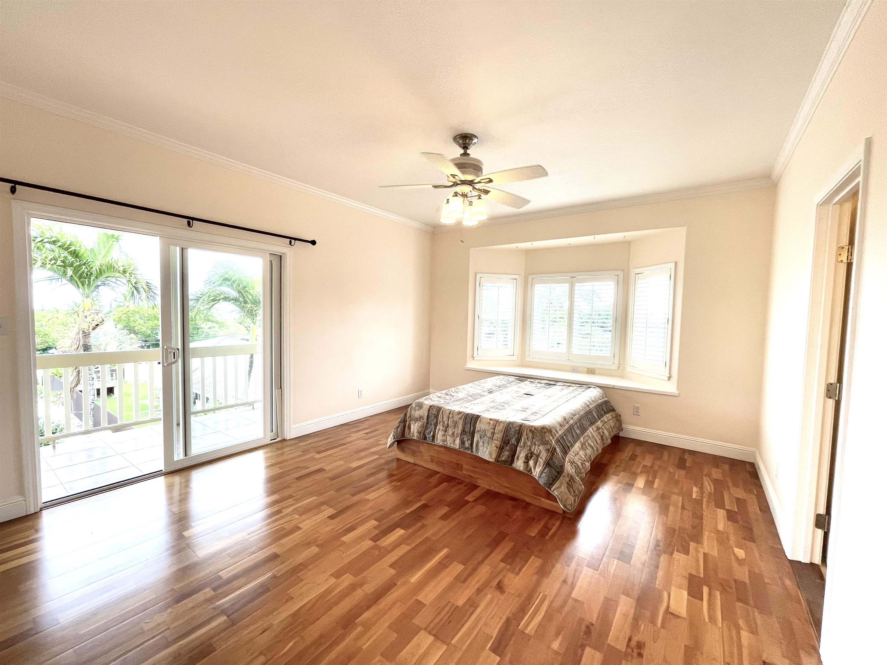 22 Hale Lio Place Haiku, HI 96708 - Photo 17 of 50 a spacious bedroom with a large bed and wooden floor