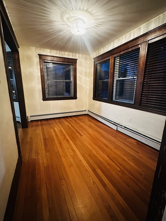 21 Prescott Street, Unit 1 Winthrop, MA 02152 - Photo 9 of 20 a view of an empty room with wooden floor and a window