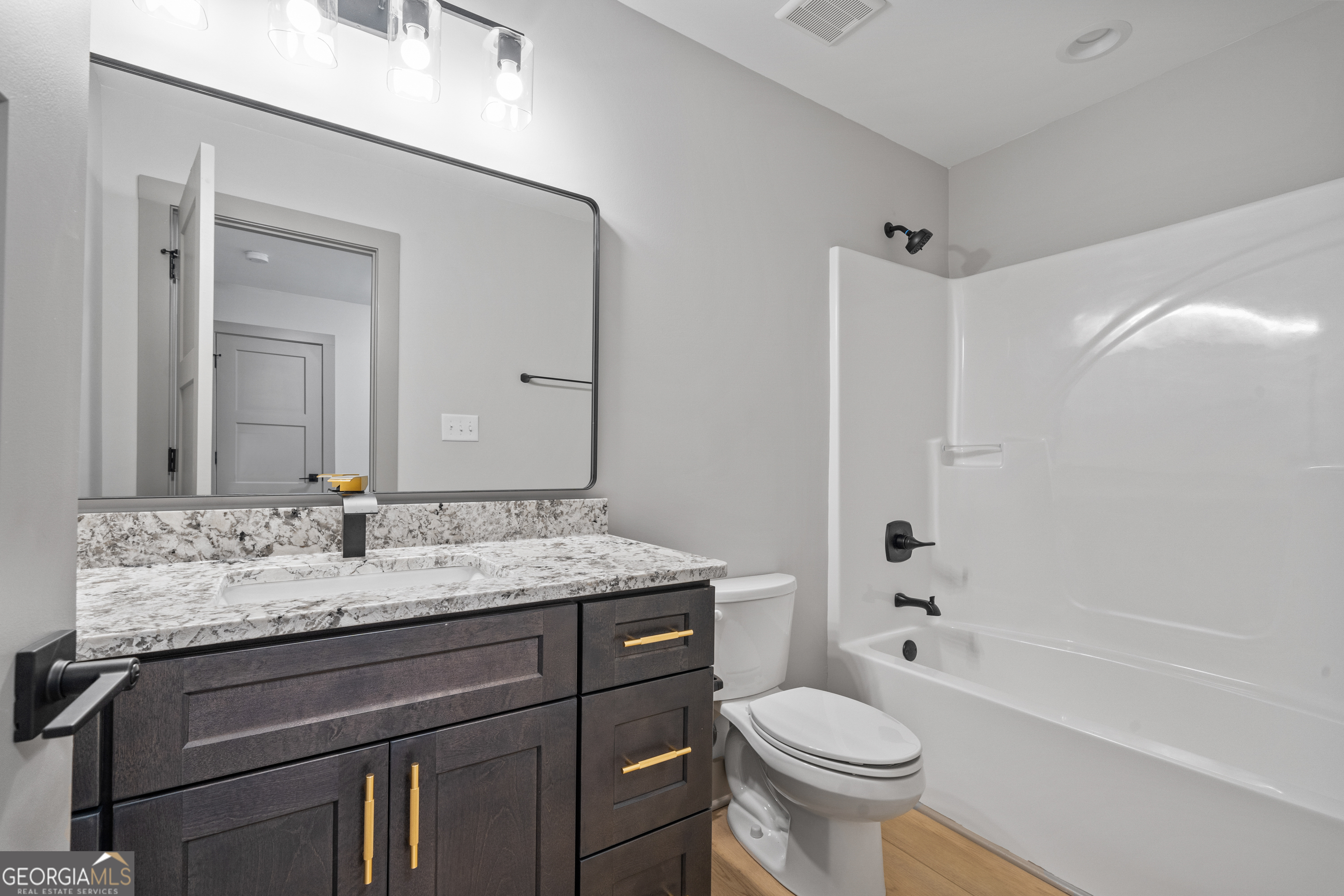 303 Tumbling Shoals Court Gray, GA 31032 - Photo 58 of 86 a bathroom with a granite countertop toilet sink and mirror