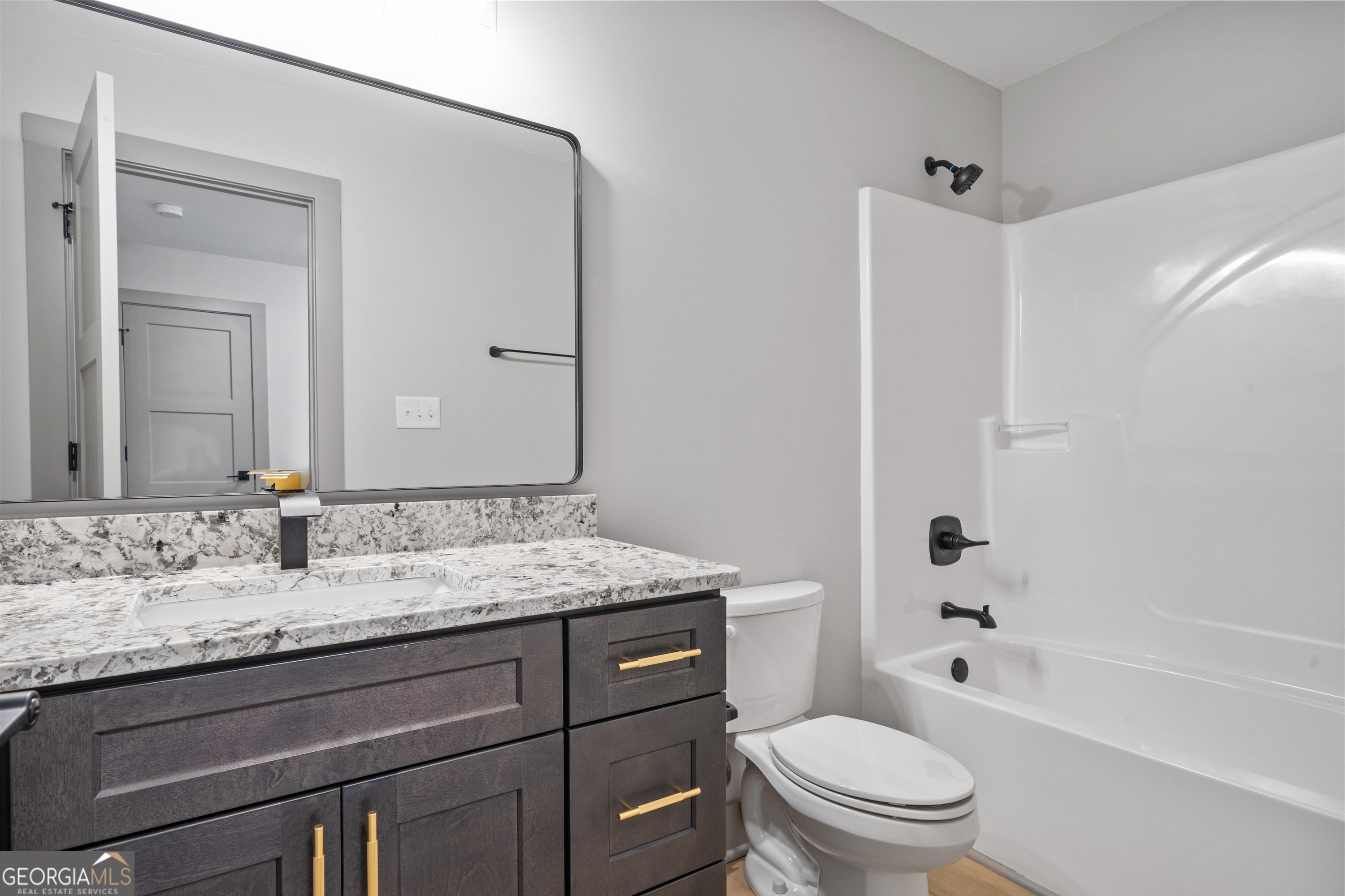 303 Tumbling Shoals Court Gray, GA 31032 - Photo 59 of 86 a bathroom with a granite countertop toilet a sink and a bathtub