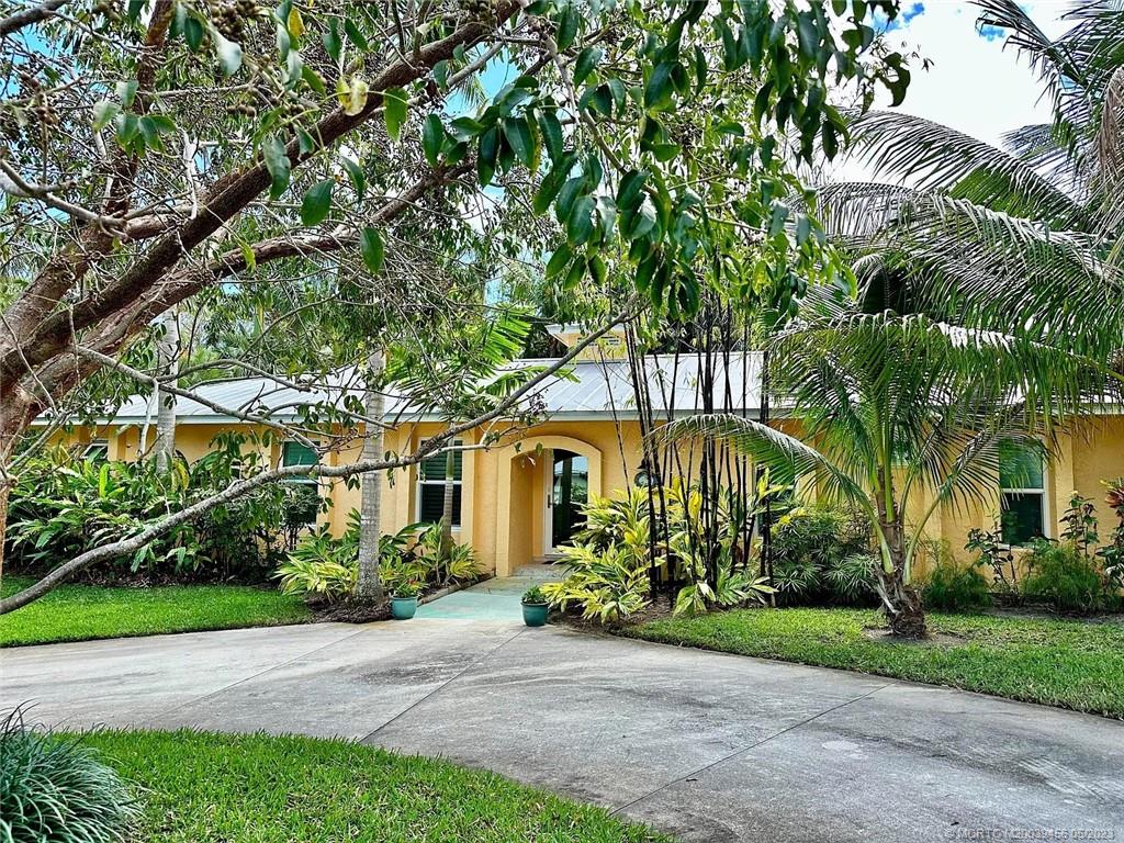 15 Miramar Road Stuart, FL 34996 - Photo 28 of 41 a front view of a house with a garden and a tree