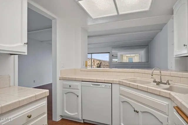 a kitchen with white cabinets and white appliances