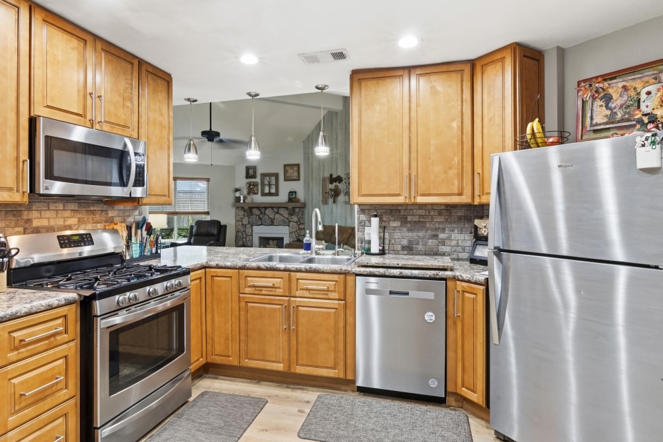 9211 Benwick Street Spring, TX 77379 - Photo 11 of 27 a kitchen with stainless steel appliances granite countertop a refrigerator stove microwave and sink