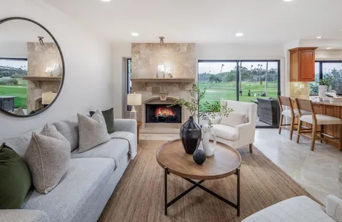 a living room with furniture fireplace and a large window