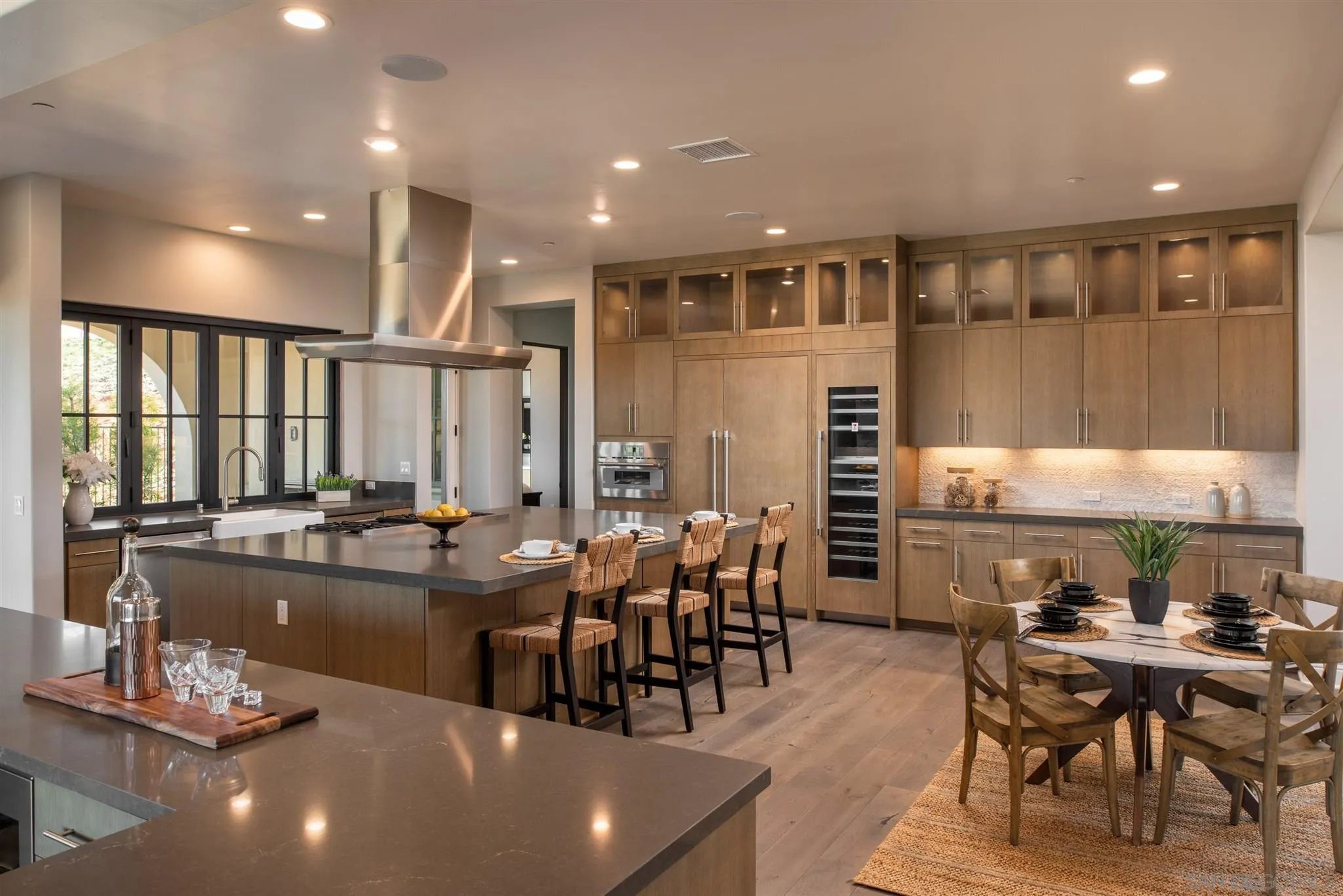 3992 Rancho Summit Drive Encinitas, CA 92024 - Photo 8 of 32 a large dining hall with stainless steel appliances granite countertop a stove and white cabinets