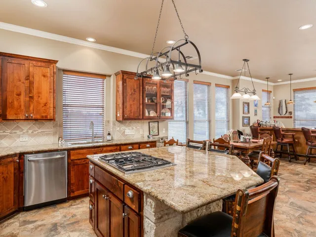 a kitchen with a stove a sink a dining table and chairs