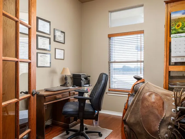 a view of a workspace with furniture and a window