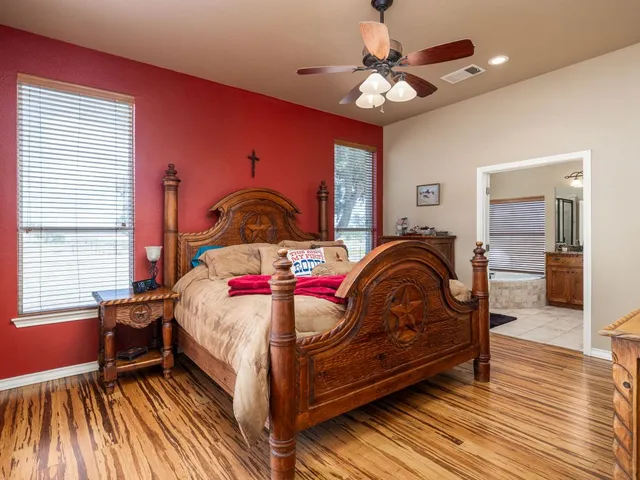 a bedroom with a bed and wooden floor