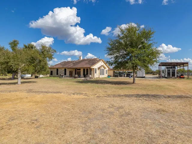 a front view of a house with a yard and trees
