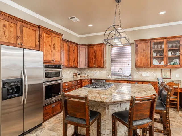 a kitchen with a sink a stove and chairs