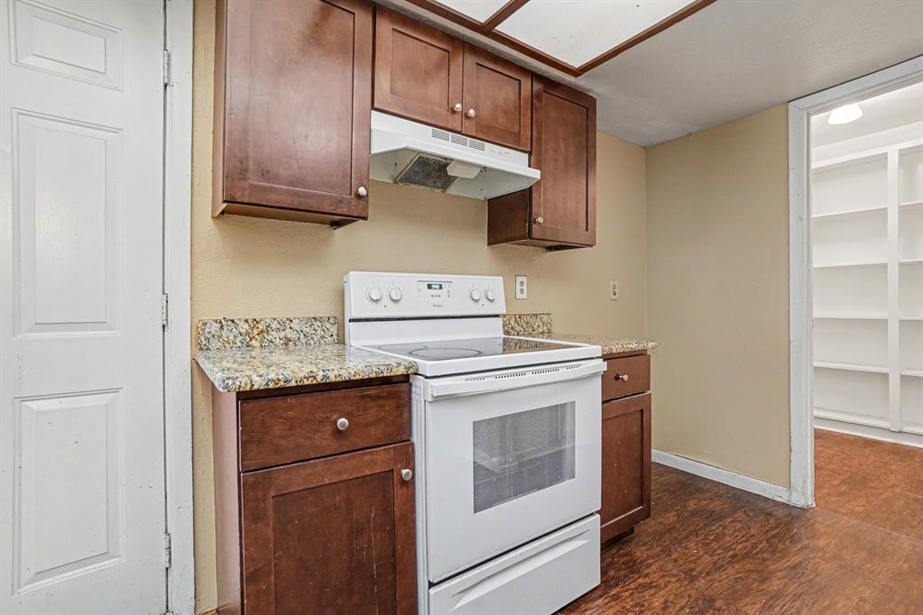 1414 Finley Road Irving, TX 75062 - Photo 10 of 27 Kitchen featuring wood-finish cabinetry, granite-style countertops, an electric range, and a built-in pantry with shelving