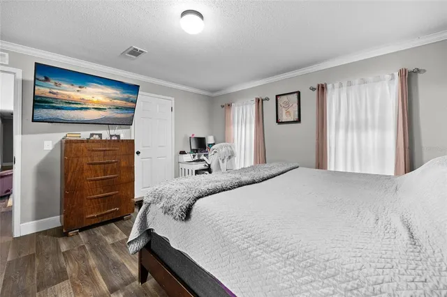 a bedroom with a bed and wooden floor