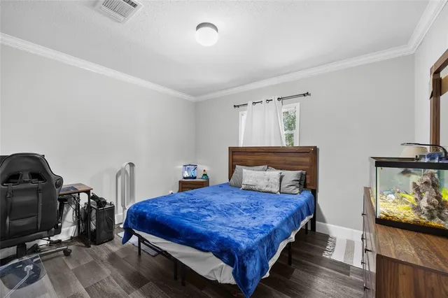 a living room with a bed and a flat screen tv