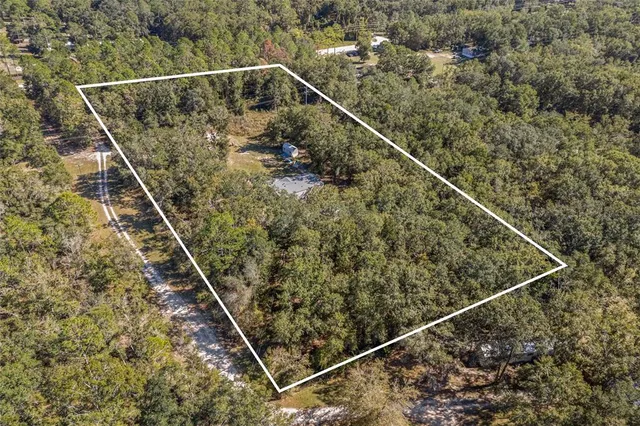 a view of a house with backyard and trees