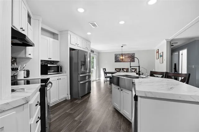 a kitchen with granite countertop a sink stove and cabinets