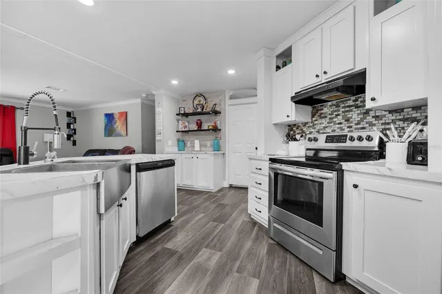 a kitchen with white cabinets and stainless steel appliances