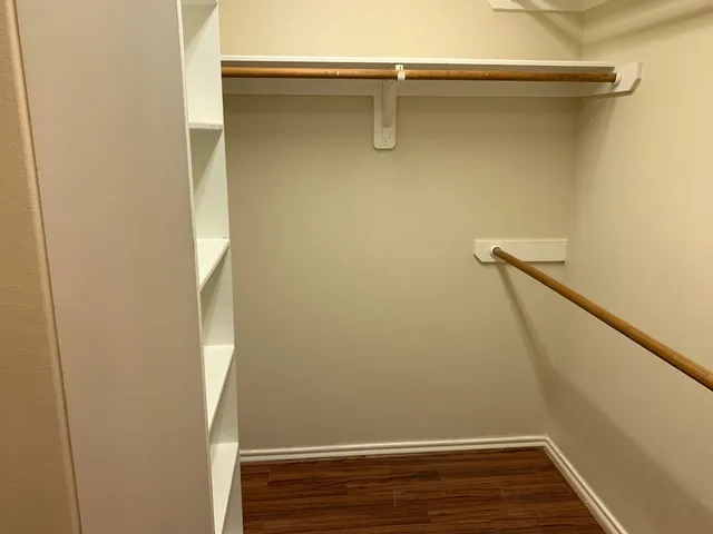 a view of closet with wooden floor