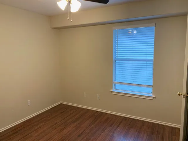 a view of a small space with wooden floor and a window