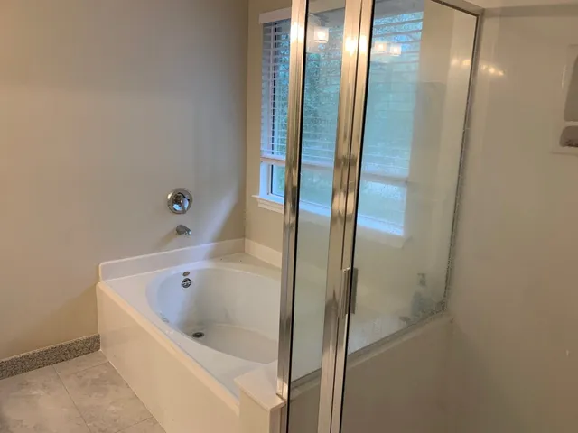a bathroom with a bathtub and shower