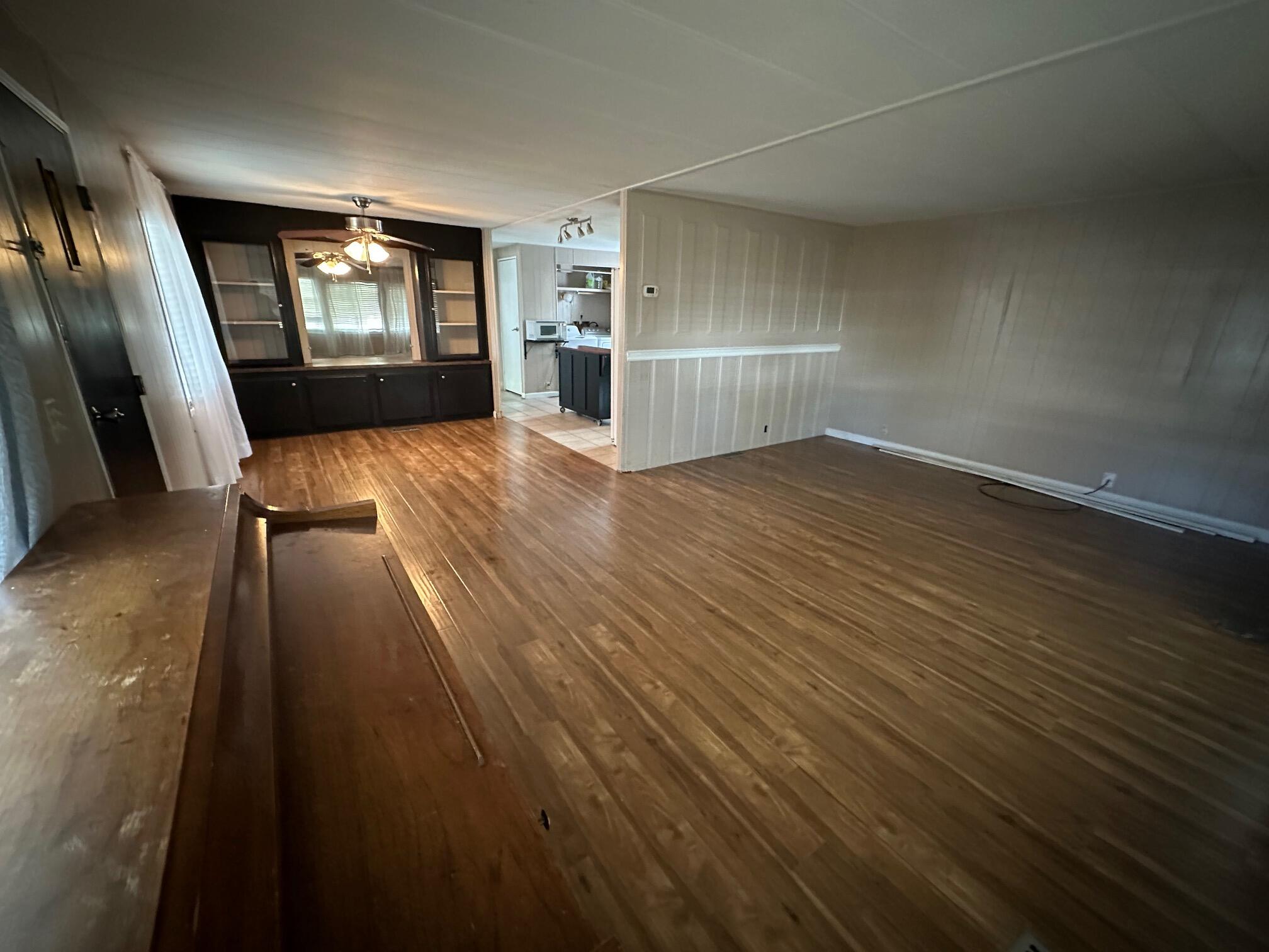 421 Stevens Road, Unit 52 Eagle Point, OR 97524 - Photo 4 of 18 an empty room with wooden floor and a kitchen