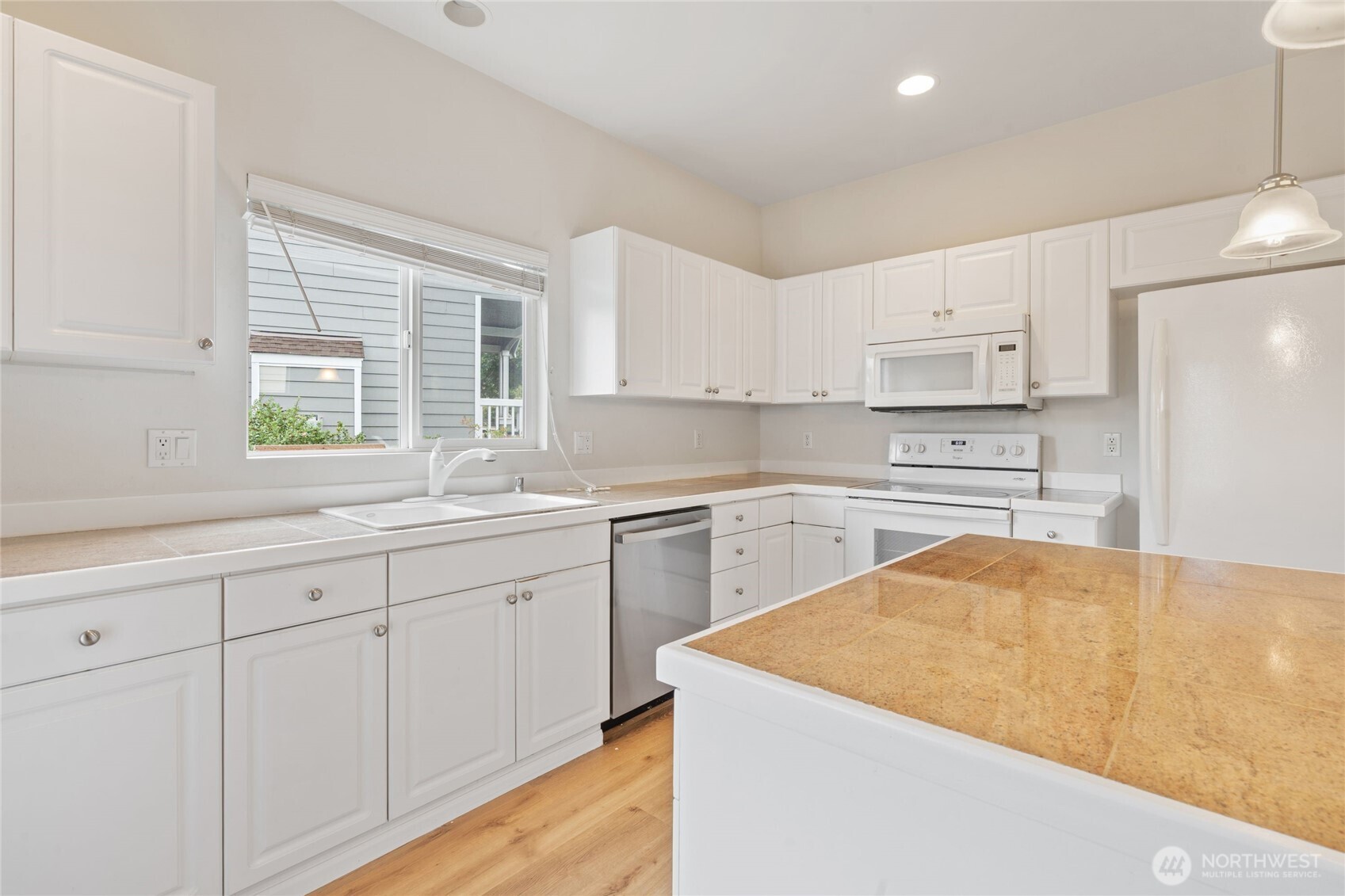 16919 165th Place Southeast Renton, WA 98058 - Photo 12 of 29 a kitchen with granite countertop white cabinets and white appliances