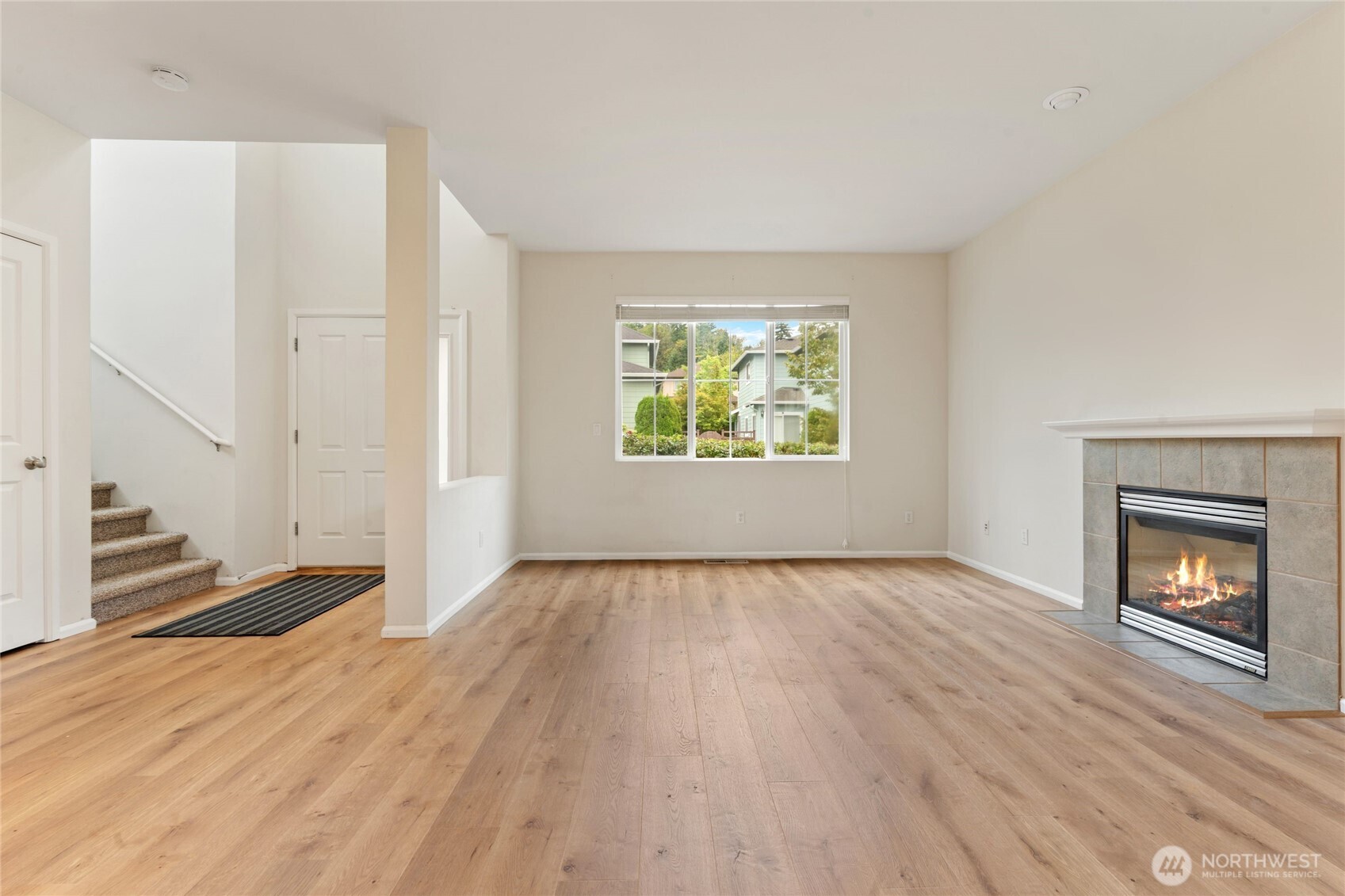 16919 165th Place Southeast Renton, WA 98058 - Photo 6 of 29 an empty room with wooden floor fireplace and windows