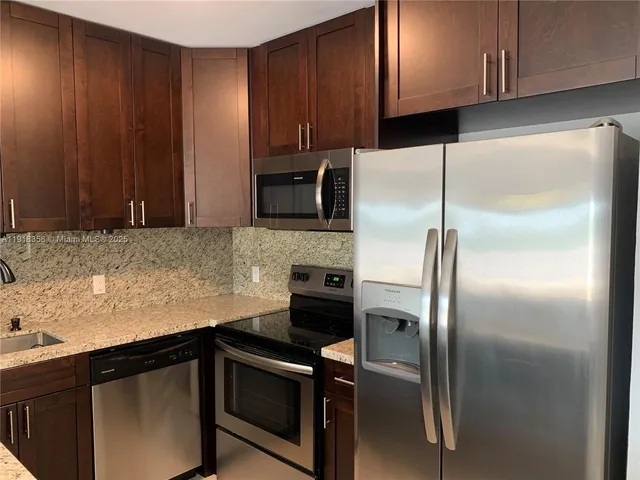 a kitchen with a refrigerator and cabinets