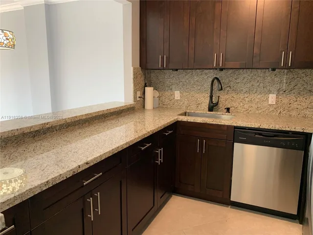 a kitchen with granite countertop cabinets sink and cabinets