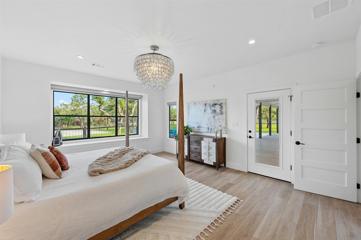 333 Stallion Lane Dripping Springs, TX 78620 - Photo 15 of 40 a spacious bedroom with a bed and a dresser next to a window