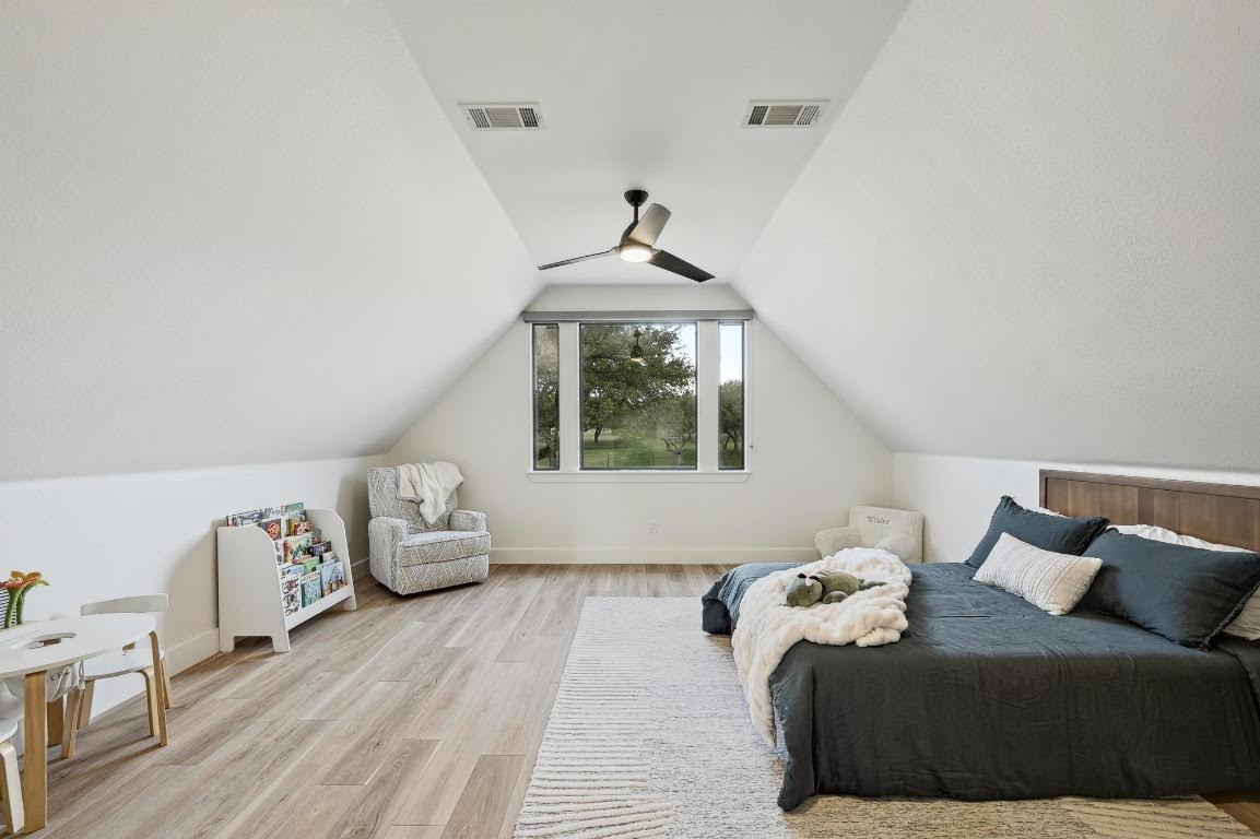 333 Stallion Lane Dripping Springs, TX 78620 - Photo 23 of 40 a bedroom with bed and wooden floor