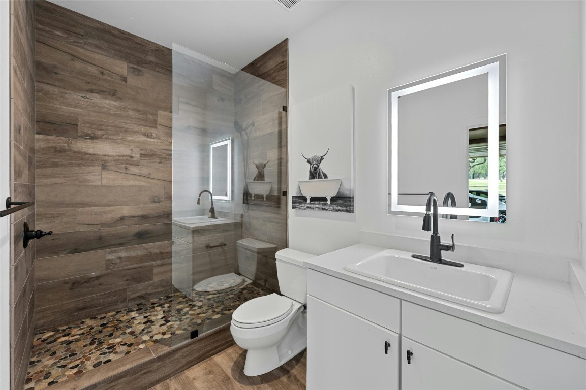 333 Stallion Lane Dripping Springs, TX 78620 - Photo 31 of 40 a bathroom with a sink a toilet and shower